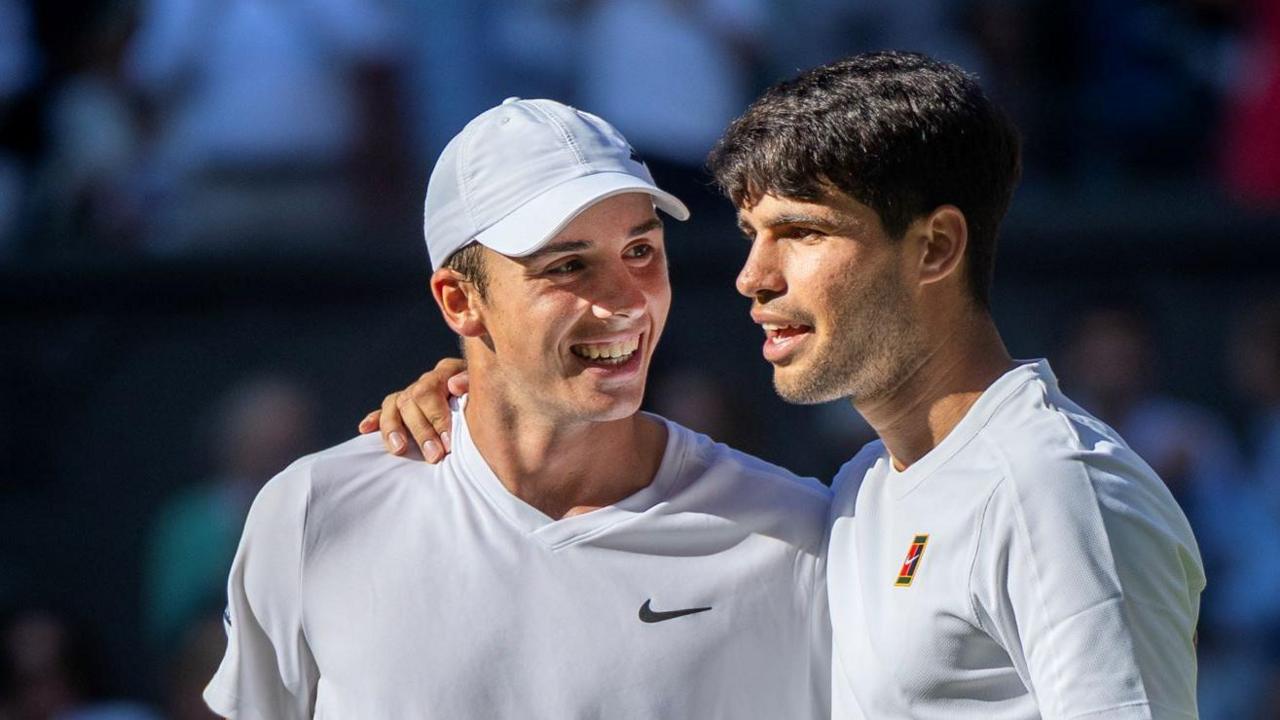 Oliver Tarvet is embraced by Carlos Alcaraz after their Wimbledon match