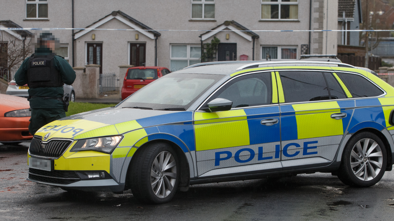 Police officer in uniform and yellow and blue police vehicle at Breezemount Close in Conlig