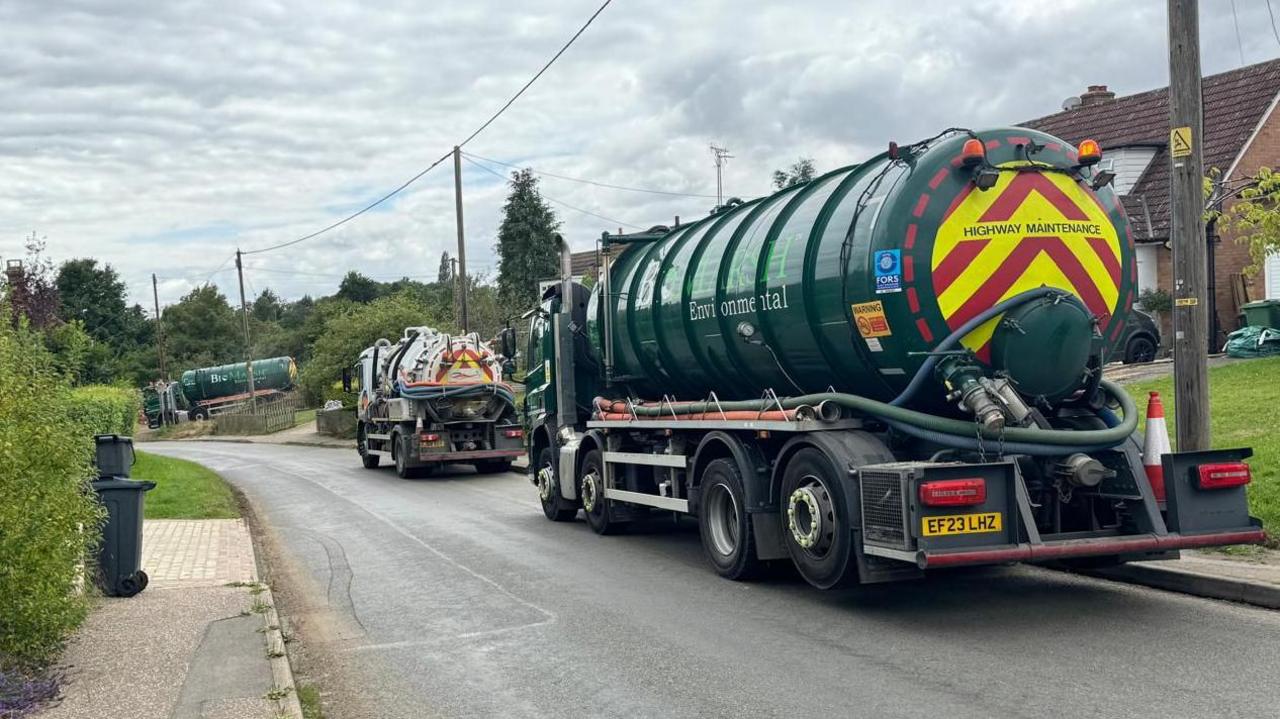 Sewage tankers parked along a road in Great Easton