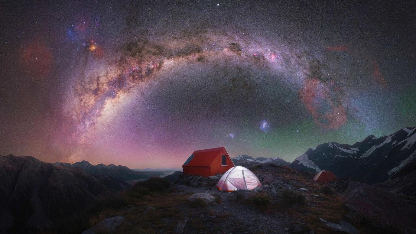 A beautiful campsite scene with the Milky Way stretching in an arc in the sky. 