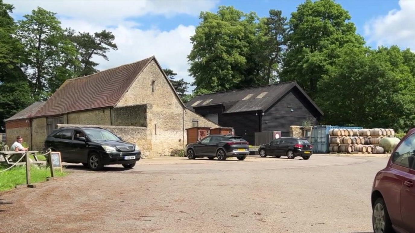 Two barns with barrels to the right hand side