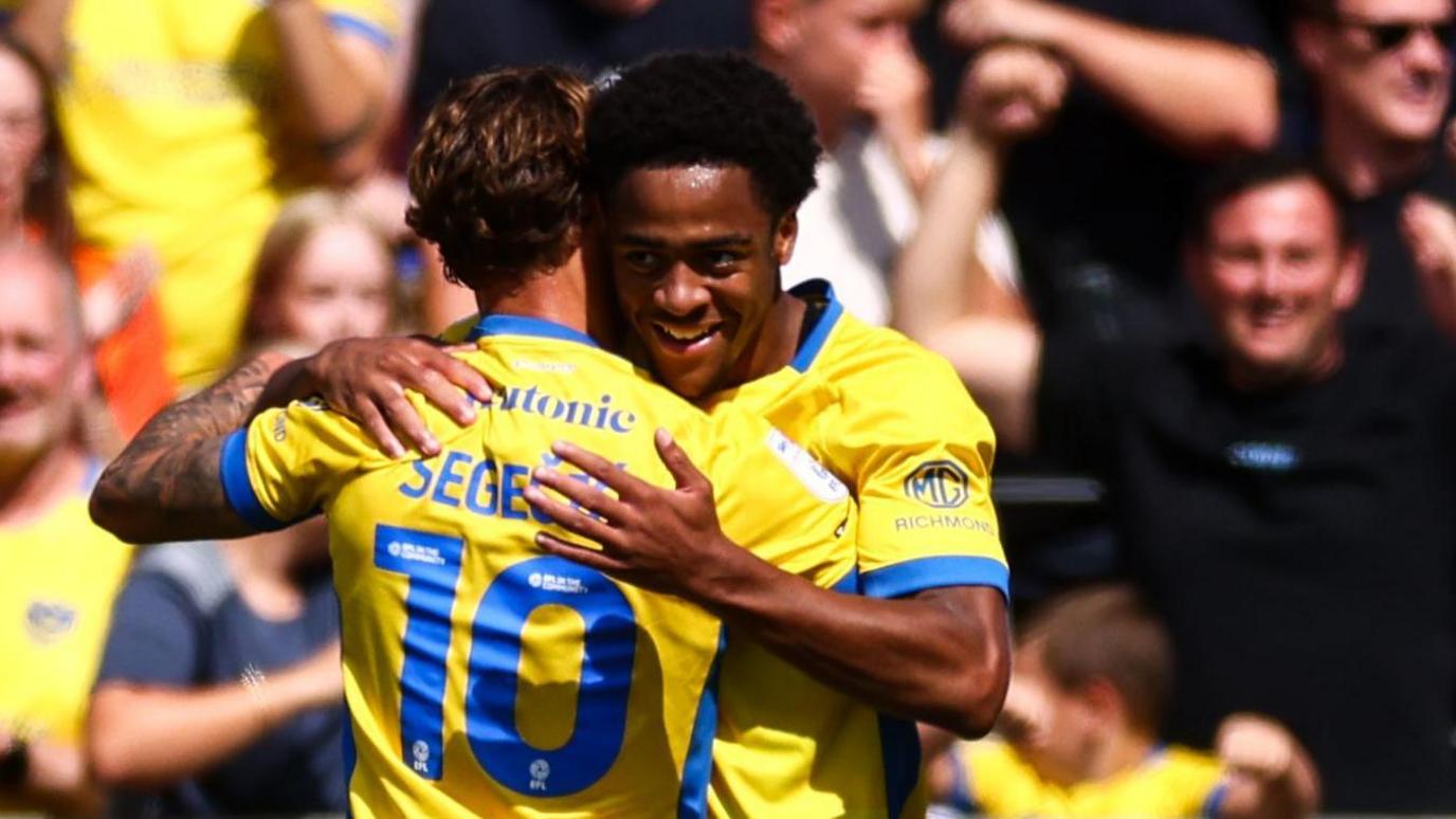 Adrian Segecic gets a hug from Ryan Kuvuma-McQueen after scoring Portsmouth's second against Lincoln CIty