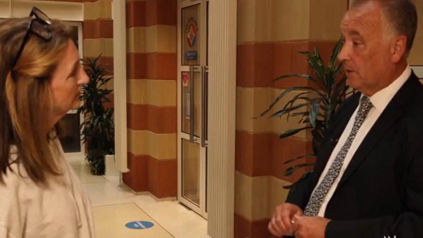 Epping Forest District Council leader, Chris Whitbread stands in council building corridor with the BBC's Victoria Derbyshire