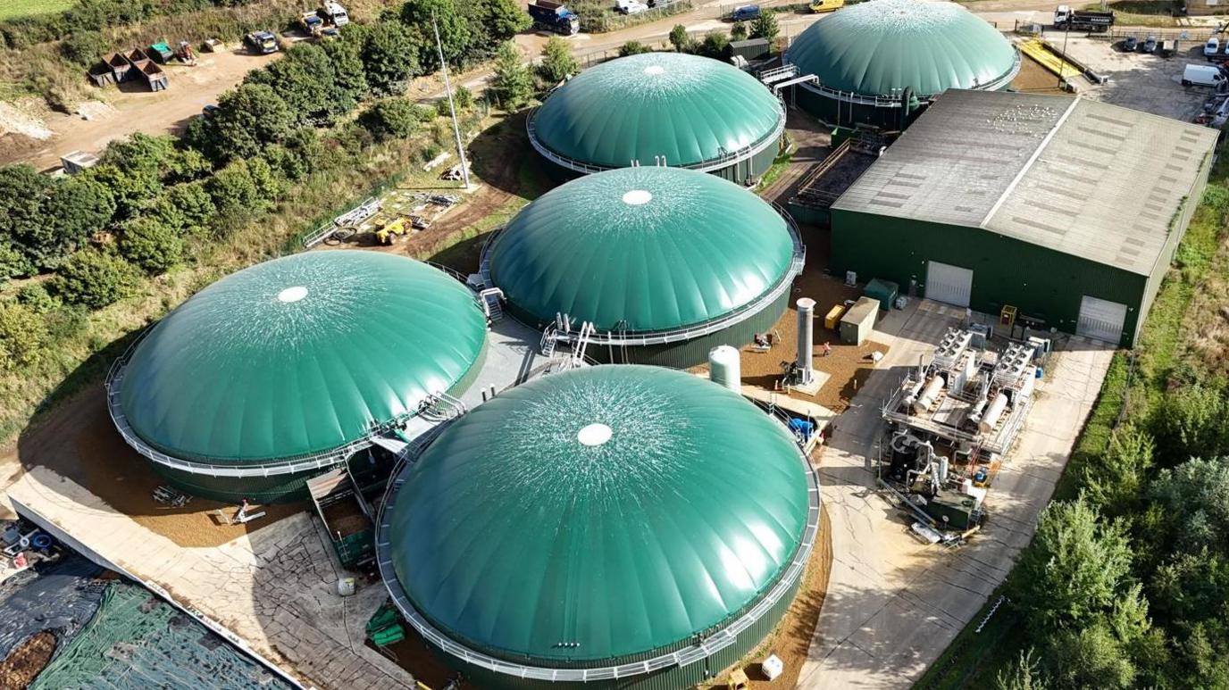 A bird's eye view of the site from September. All the tanks have been repaired. They have green roofs. It's sunny.