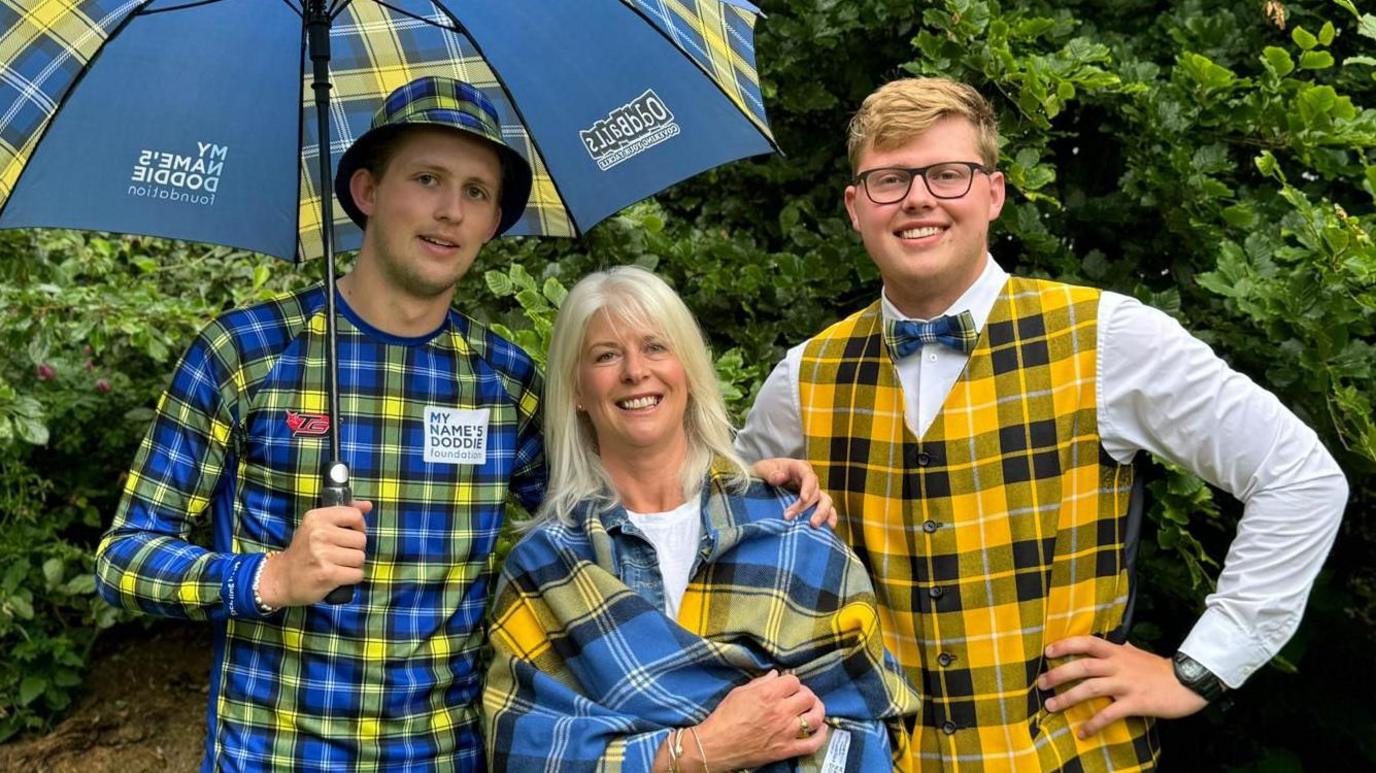 Hamish Weir, Kathy Weir and Ben Weir in tartan