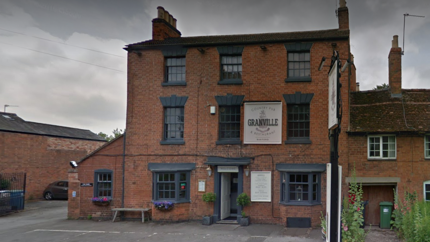 The outside of the Granville Arms pub with black windows. It is three storeys high and features a car park out the front of the pub.