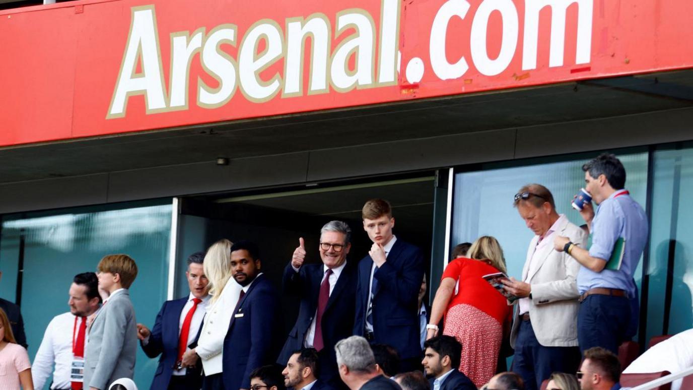 Kier Starmer with other football fans watching a match at Arsenal