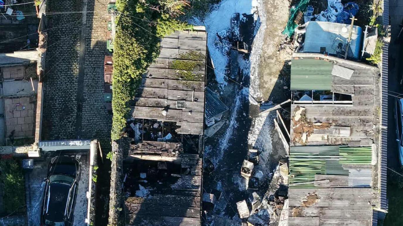 An ariel view of the garages after the fire. There is debris from the fire and fire and smoke damage.