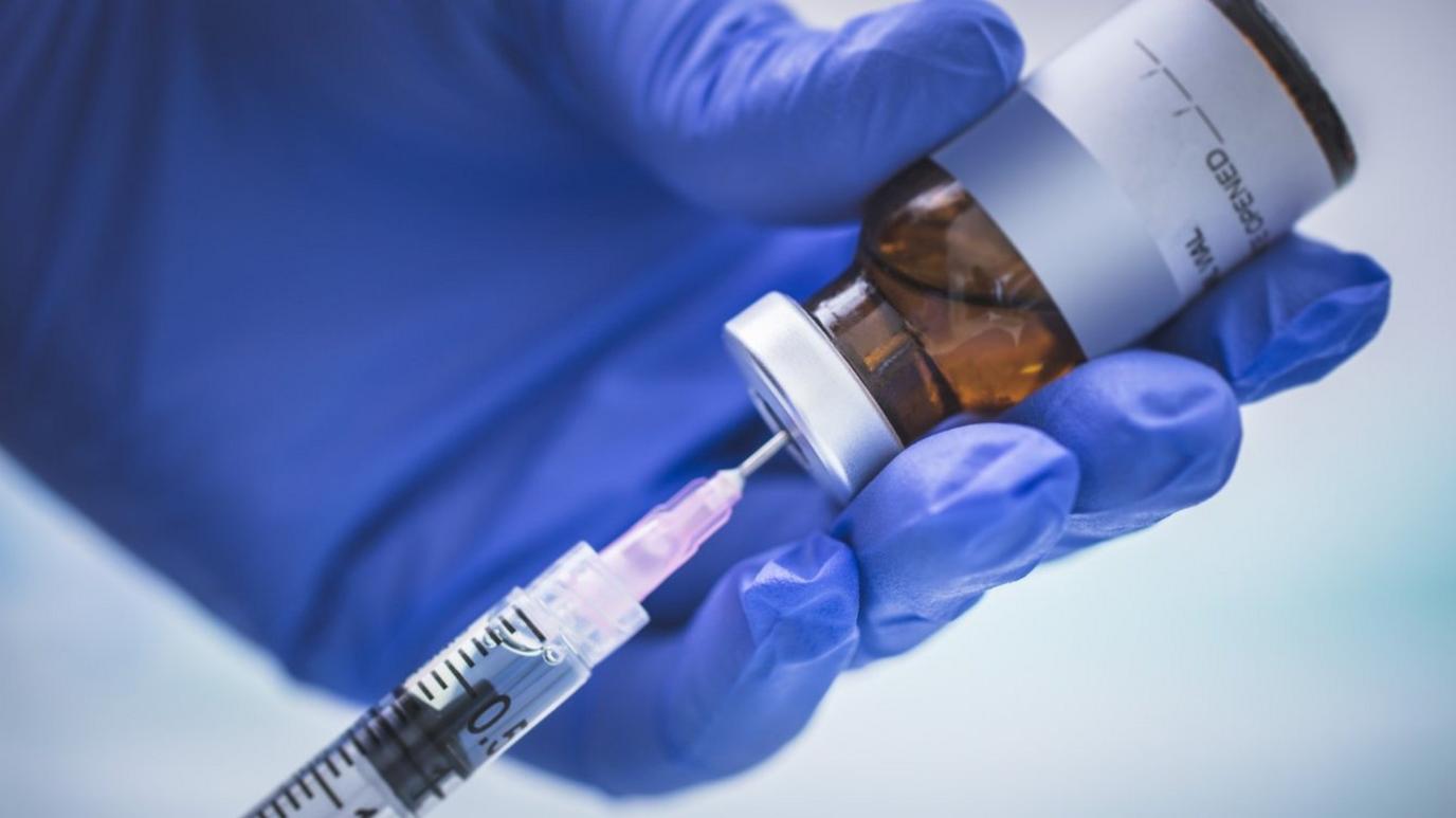 A doctor loads up a syringe