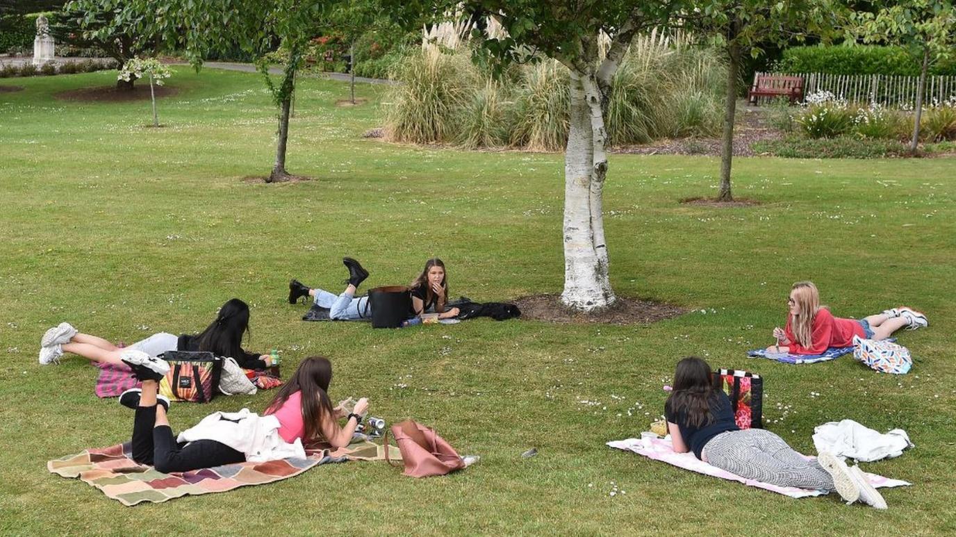 People gathering in a socially-distanced manner