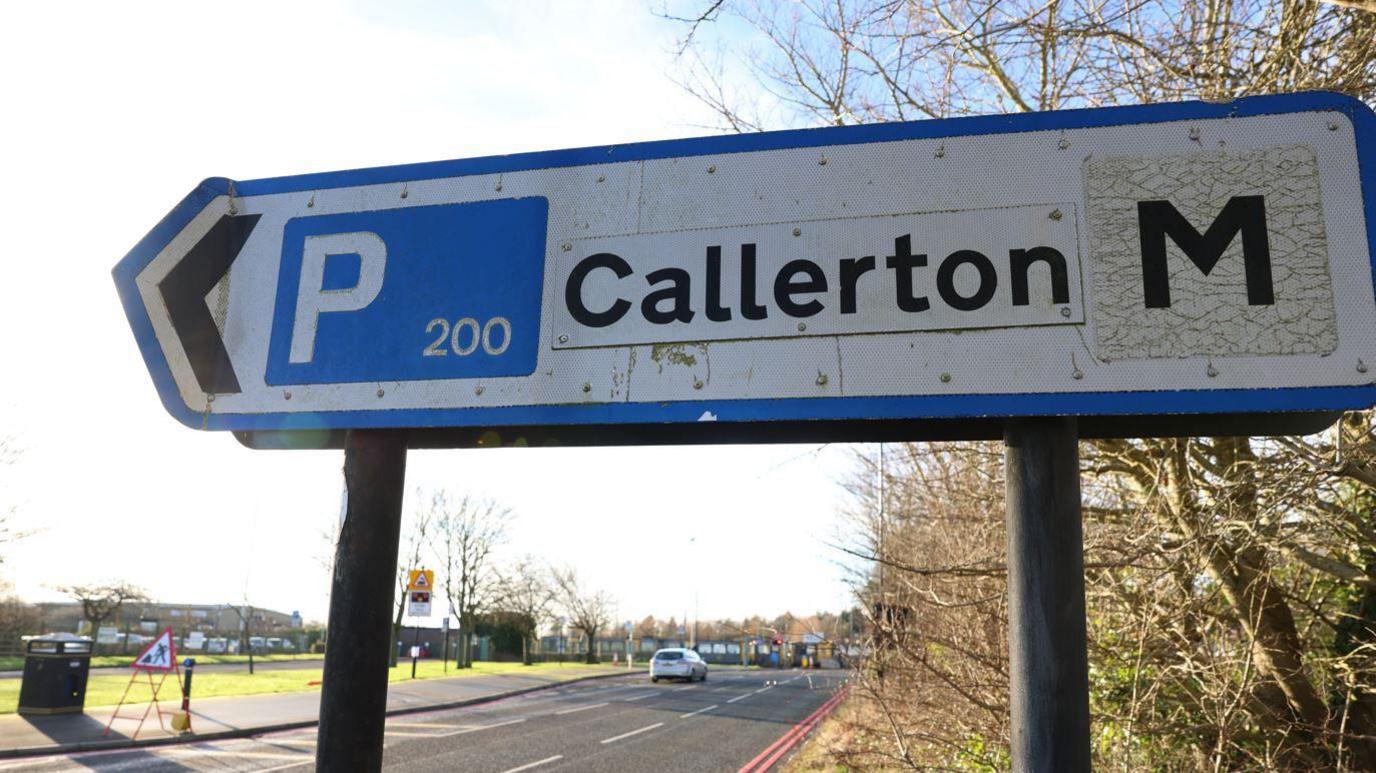 A road sign pointing to the left. It signals there are parking spaces in Callerton.