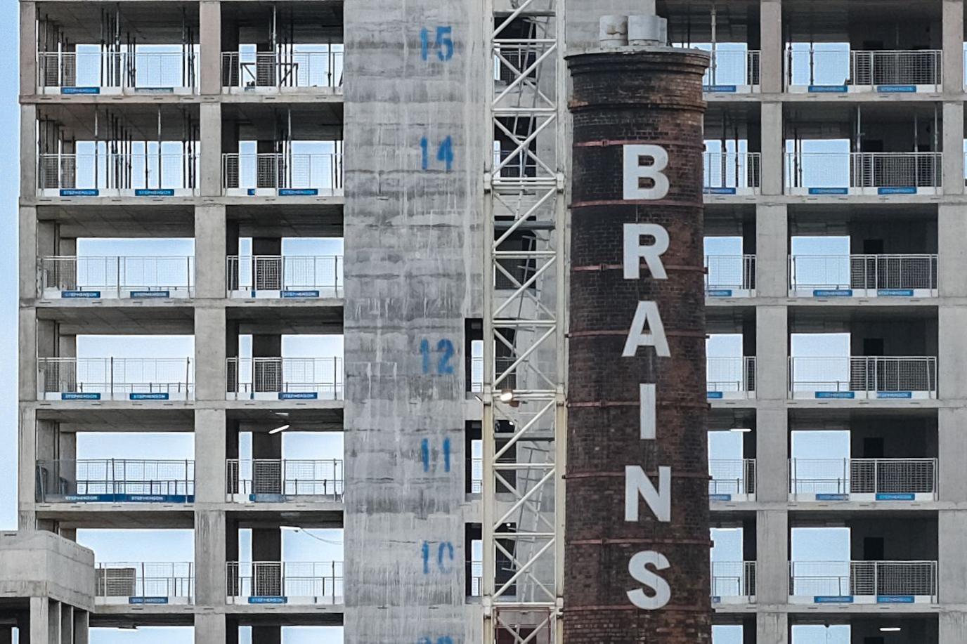 New building behind the Brains chimney in Cardiff, the new building works has each floor marked with a number 10, 11,12, then a gap, 14, 15.