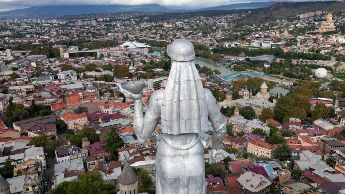 The Mother of Georgia in Tbilisi sculpture welcomes visitors with a bowl of wine, but holds a sword to symbolise Georgia's independence