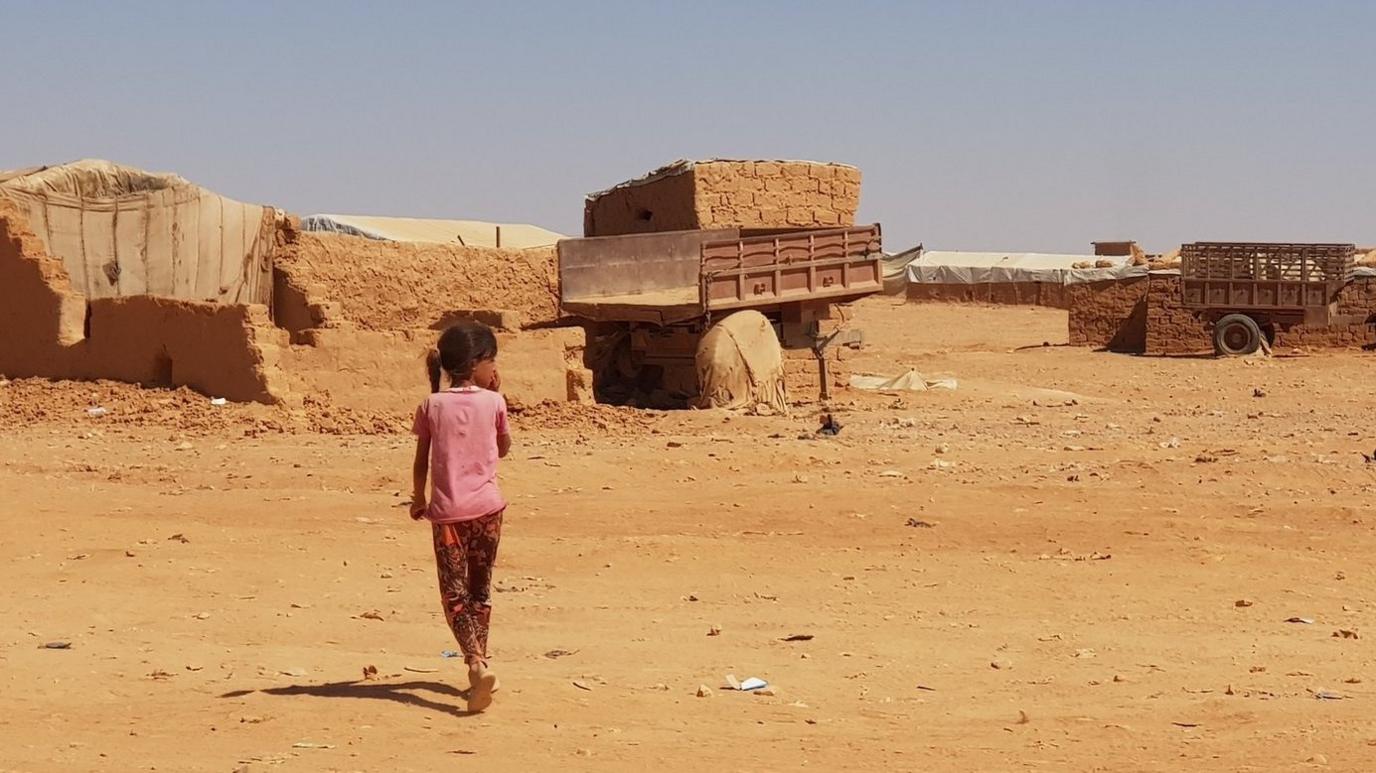 A little girl walks near makeshift shelters at Rukban camp, on the Syria-Jordan border (27 September 2018)