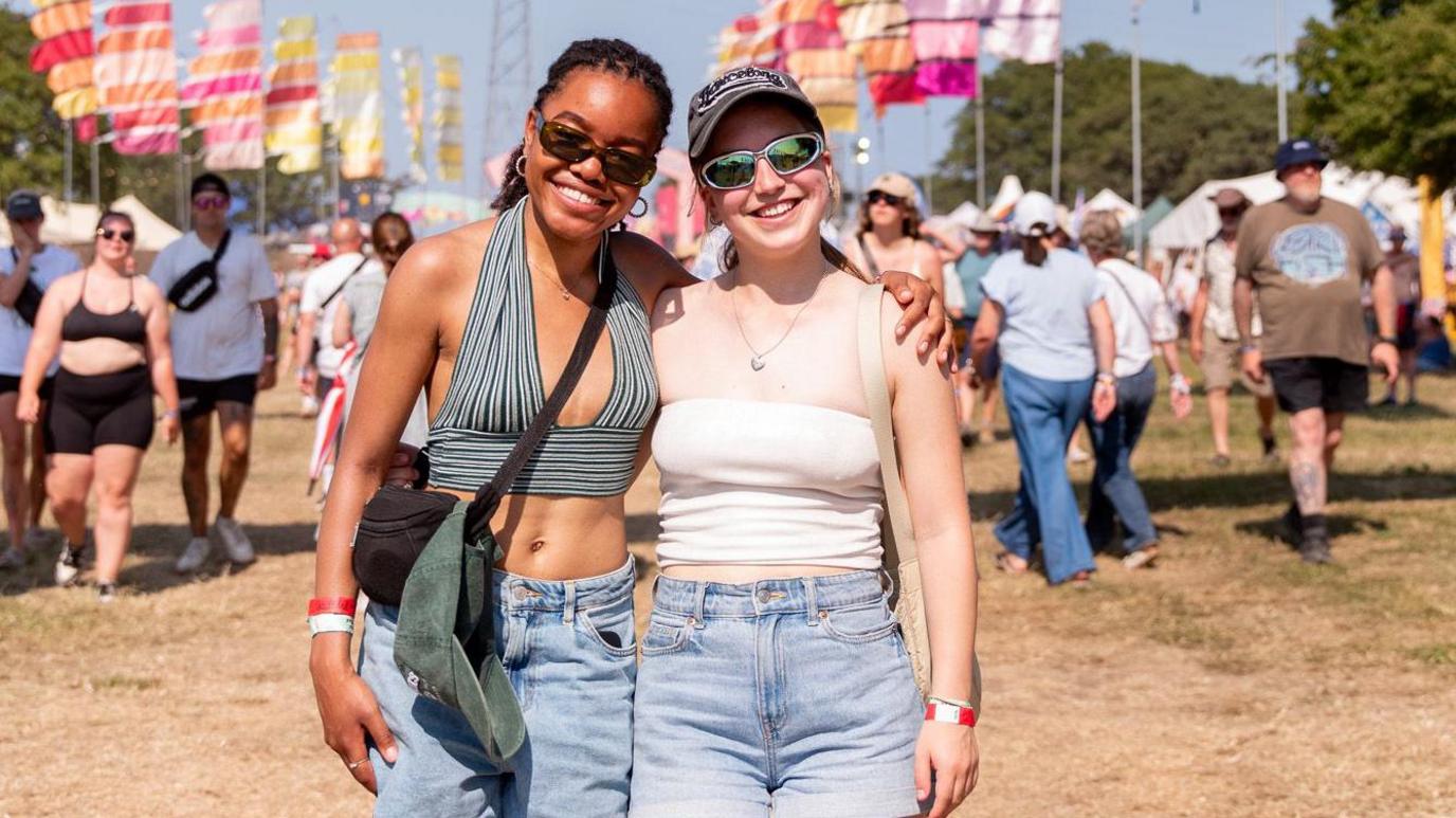 Two female festival-goers enjoy the sunshine at the Isle of Wight Festival.