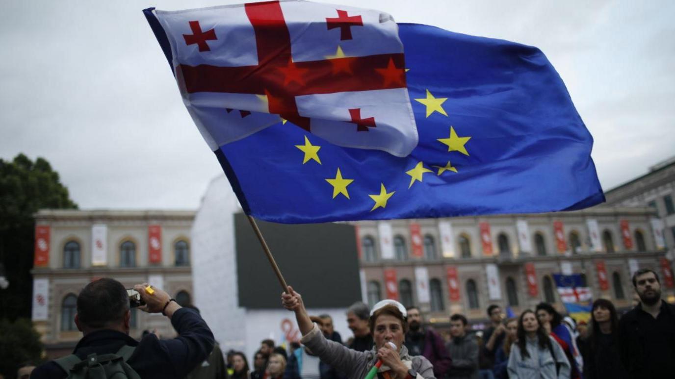 A woman waves a joint Georgia EU flag