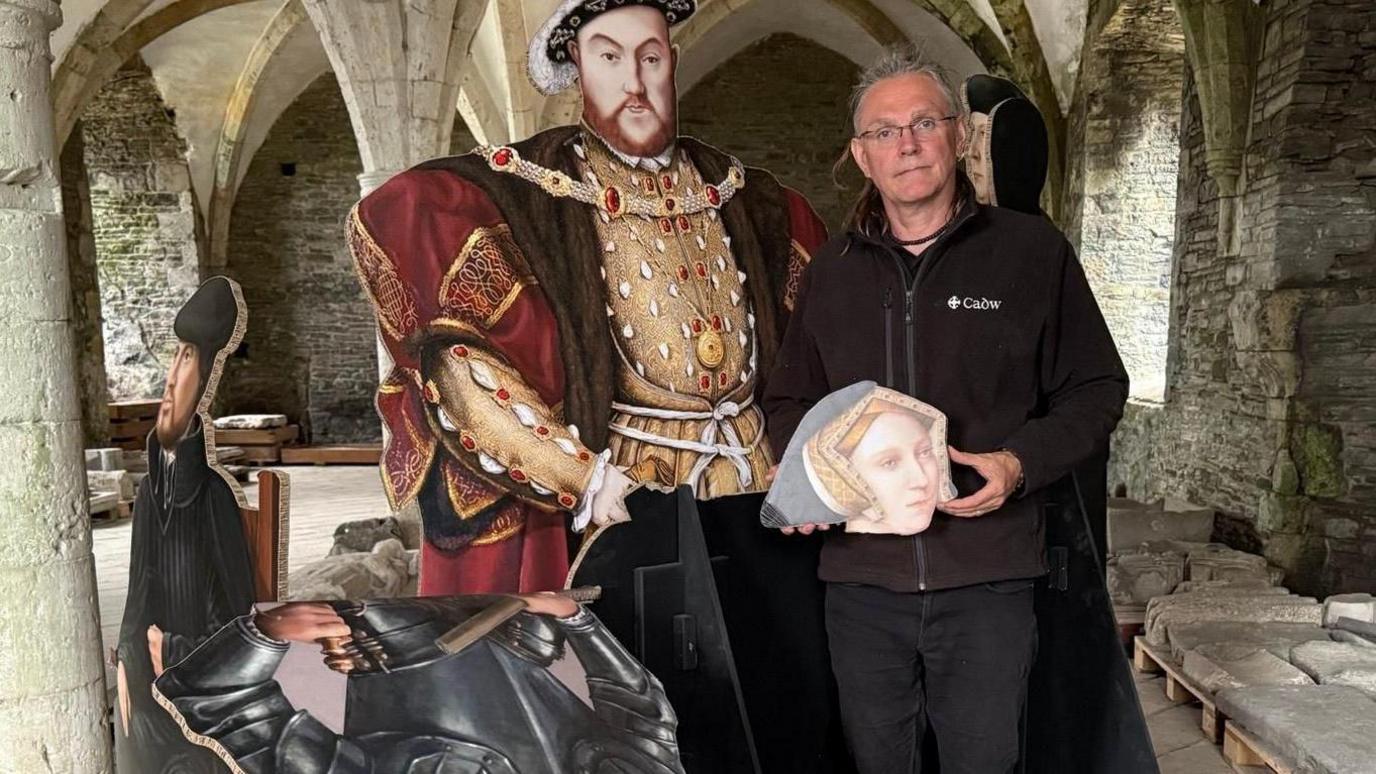 Jon Berry yn dangos difrod i arddangosfa yn Abaty Nedd