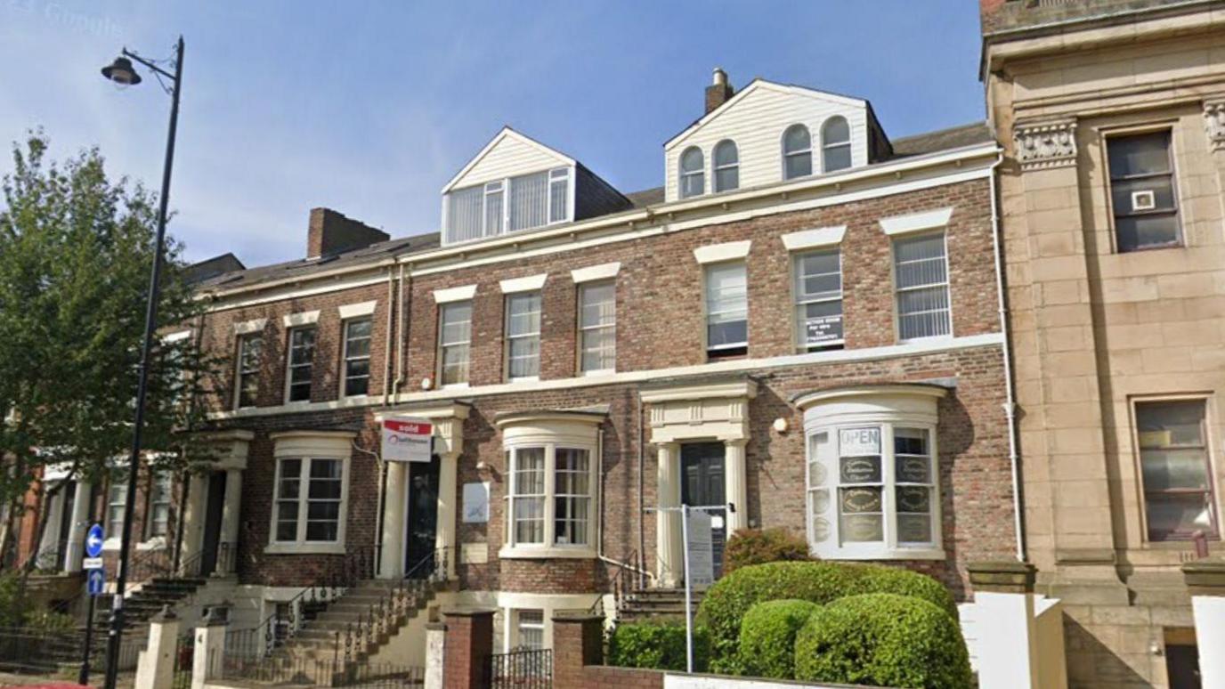 An external view of 3 and 4 Douro Terrace. It is a row of three-storey terraced buildings with brown bricks.