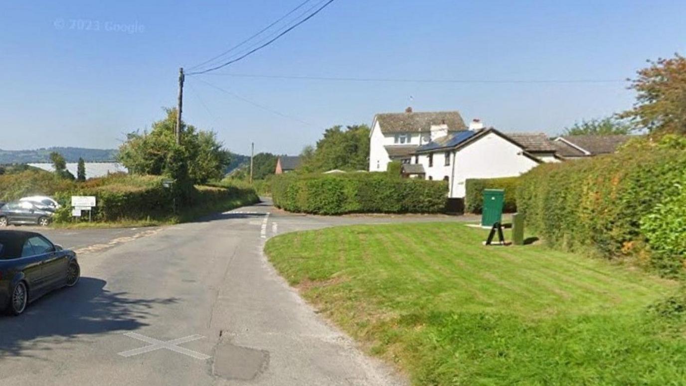 The proposed new spot for Staunton-on-Wye's war memorial, with the image showing grass by a road junction and cars on the left