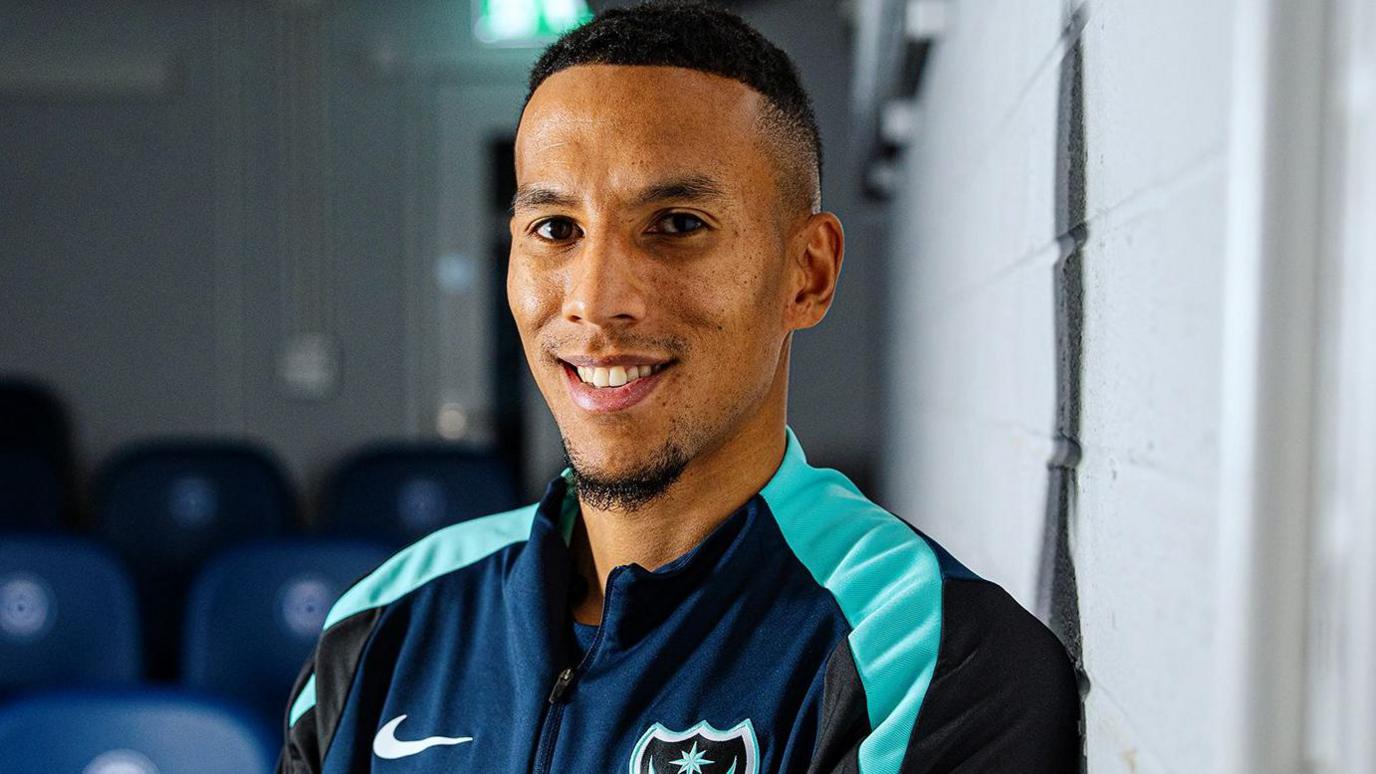 Isaac Hayden smiles in his training gear after completing his loan move to Portsmouth.