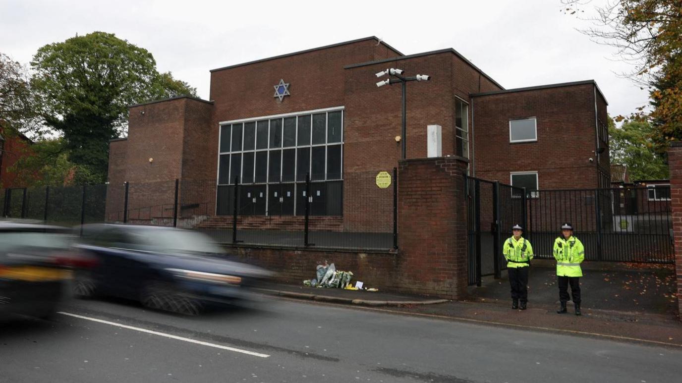 Police officers stand outside the Manchester synagogue, where multiple people were killed on Yom Kippur, in what police have declared a terrorist incident, in north Manchester.