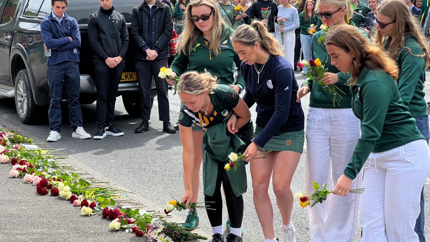 Students laying roses