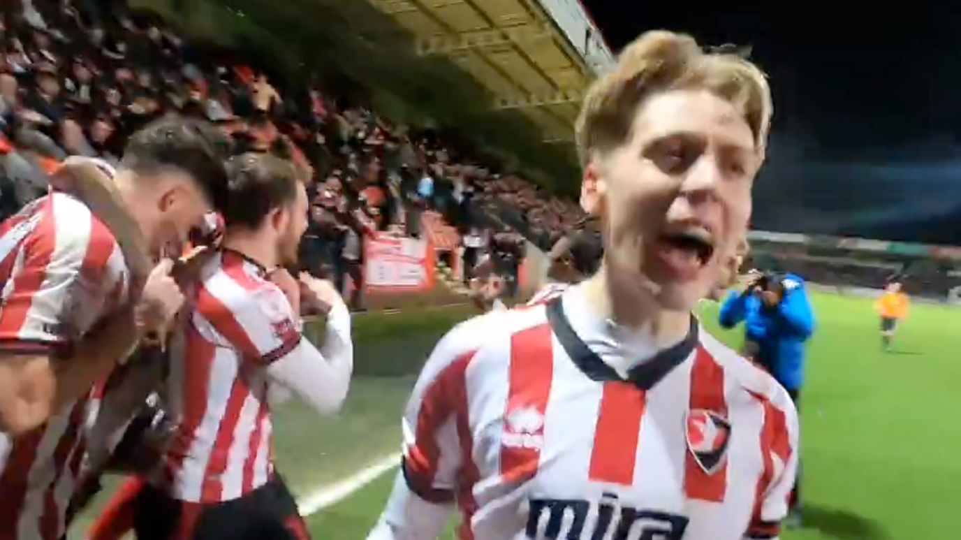 A player shouts to the crowd as teammates celebrate behind him