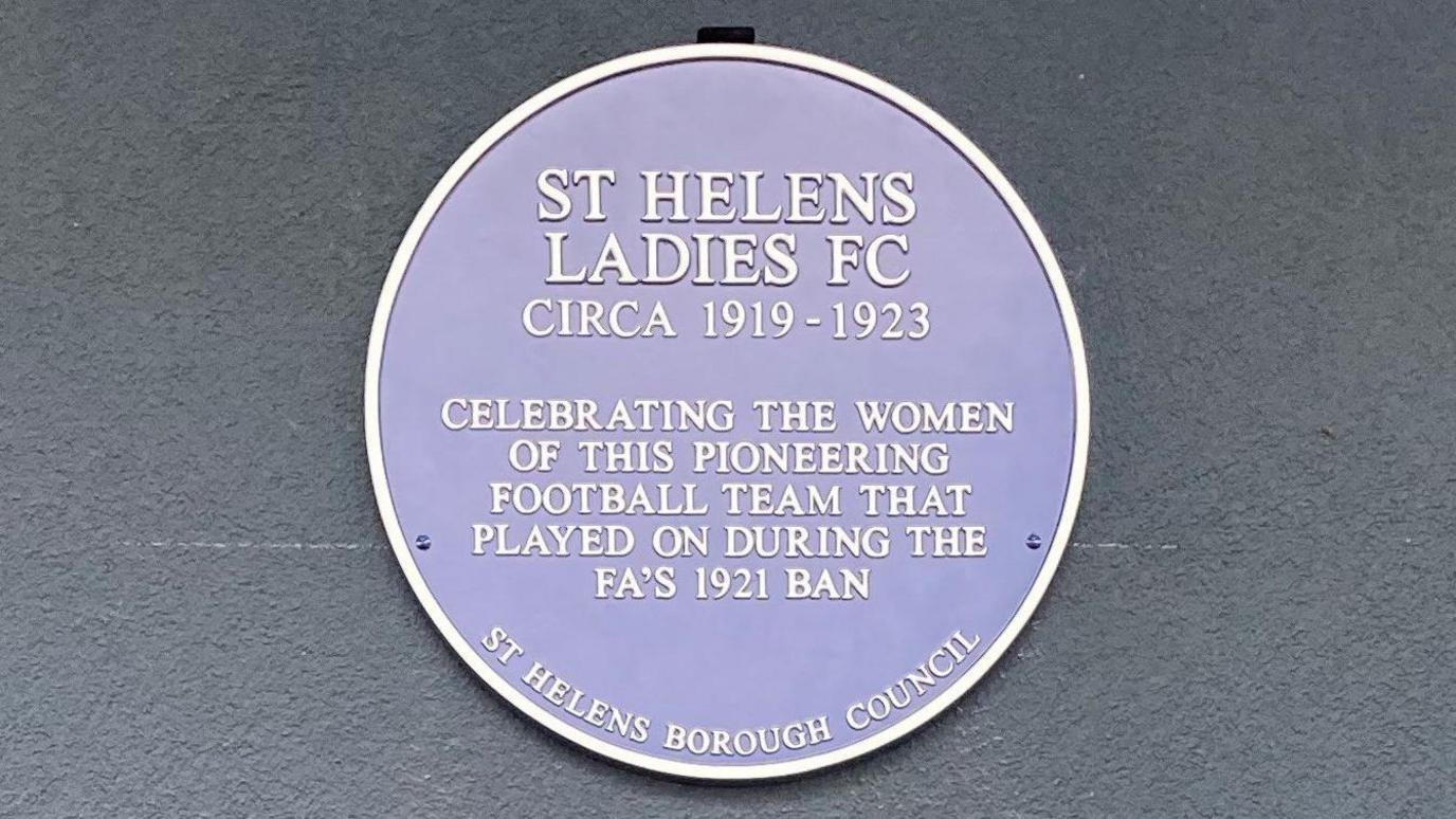 Blue plaque which reads: St Helens Ladies FC Circa 1919-1923. Celebrating the women of this pioneering football team that played on during the FA's 1921 ban. St Helens Borough Council