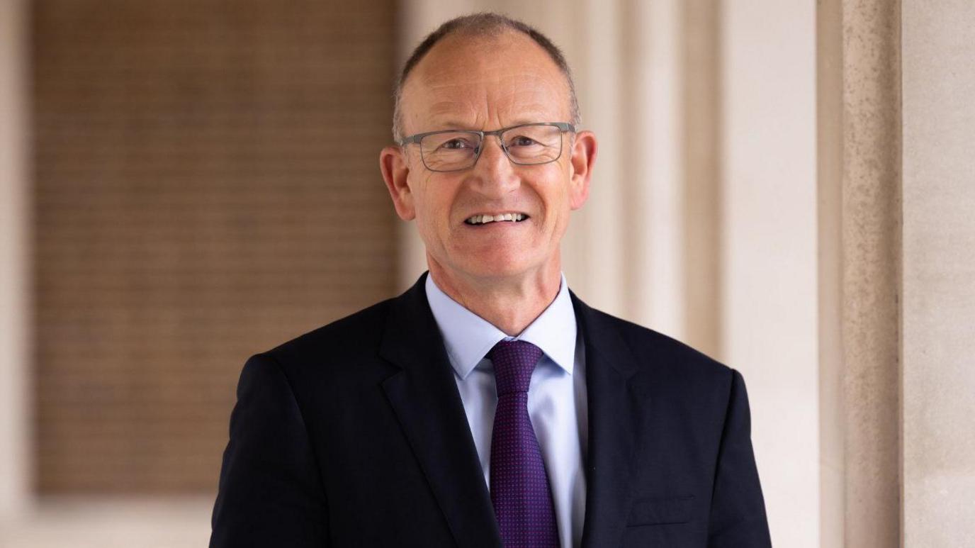 A picture of Hertfordshire County Council Leader Richard Roberts in a black jacket with a dark purple tie.