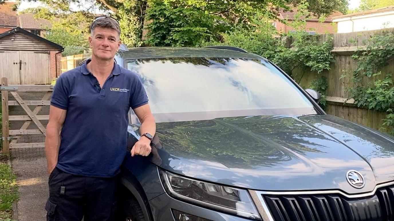 Richard Bowyer standing by his car