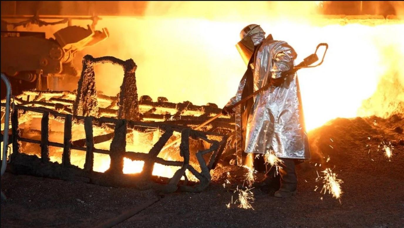 A steelworker testing molten iron quality at Blast Furnace 4 in Port Talbot