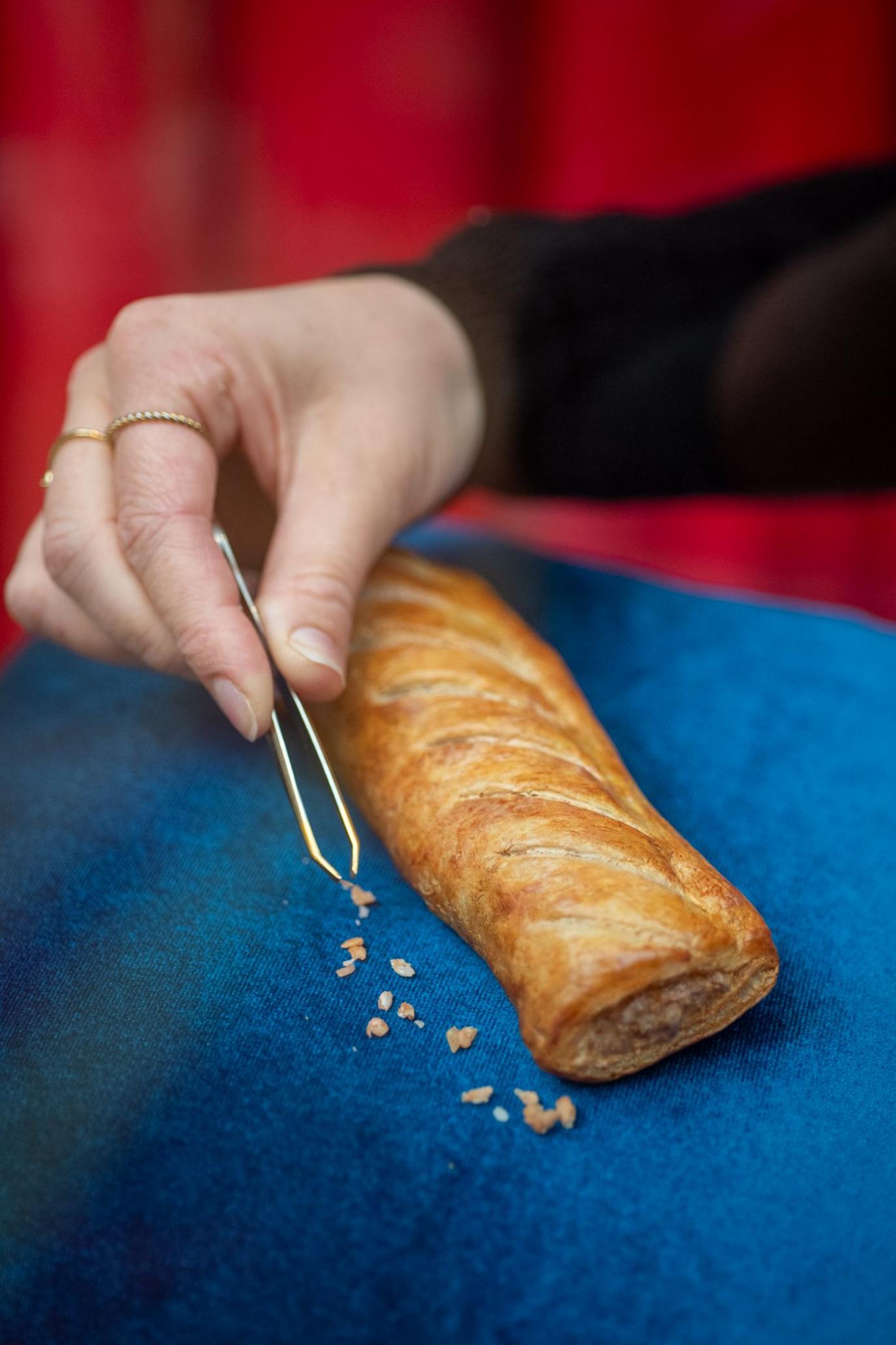 bits of crumb are added to the roll which is on a blue cushion