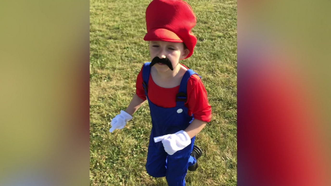 A young person in a Super Mario fancy dress outfit.