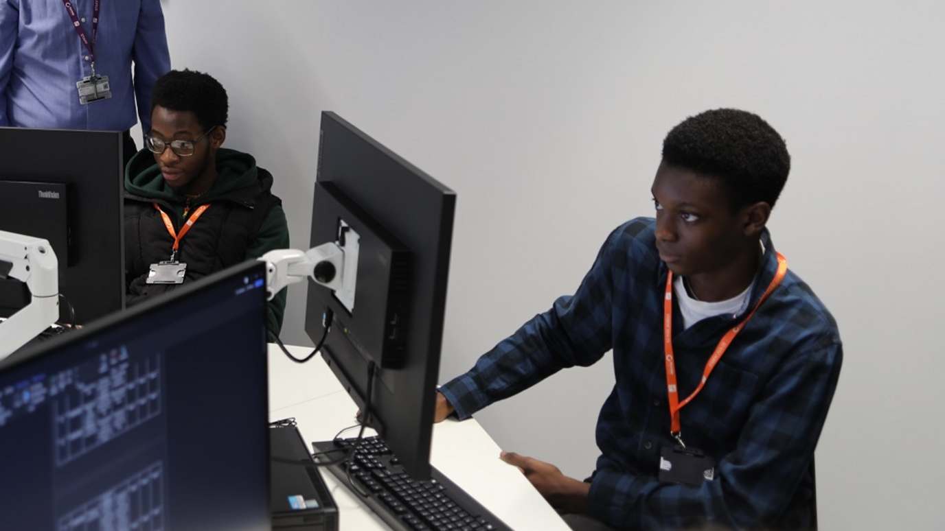 Two students at computers at the new college