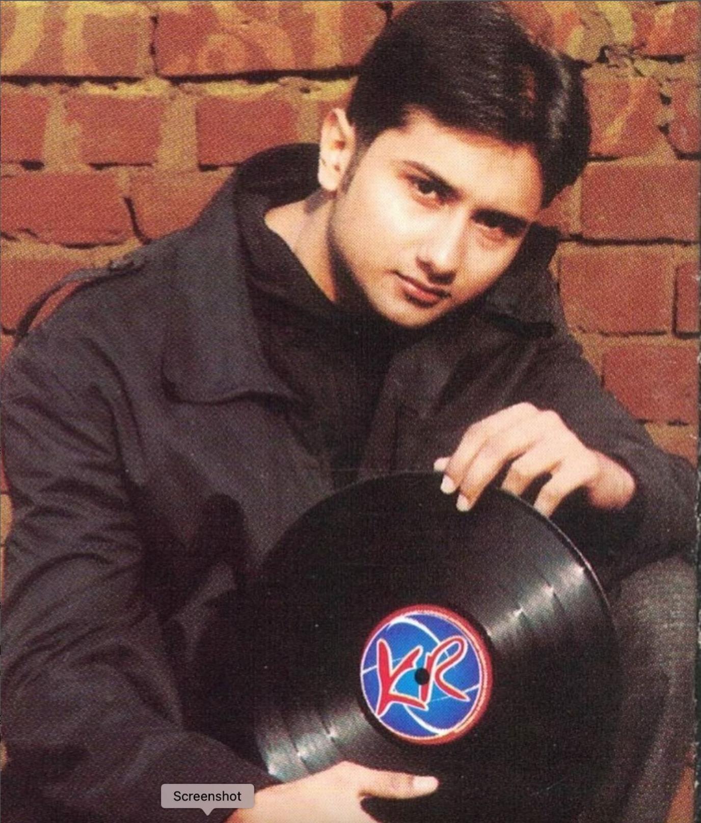 picture of Yo Yo Honey Singh from 2003 wearing a black jacket and black sweater is holding a disc 