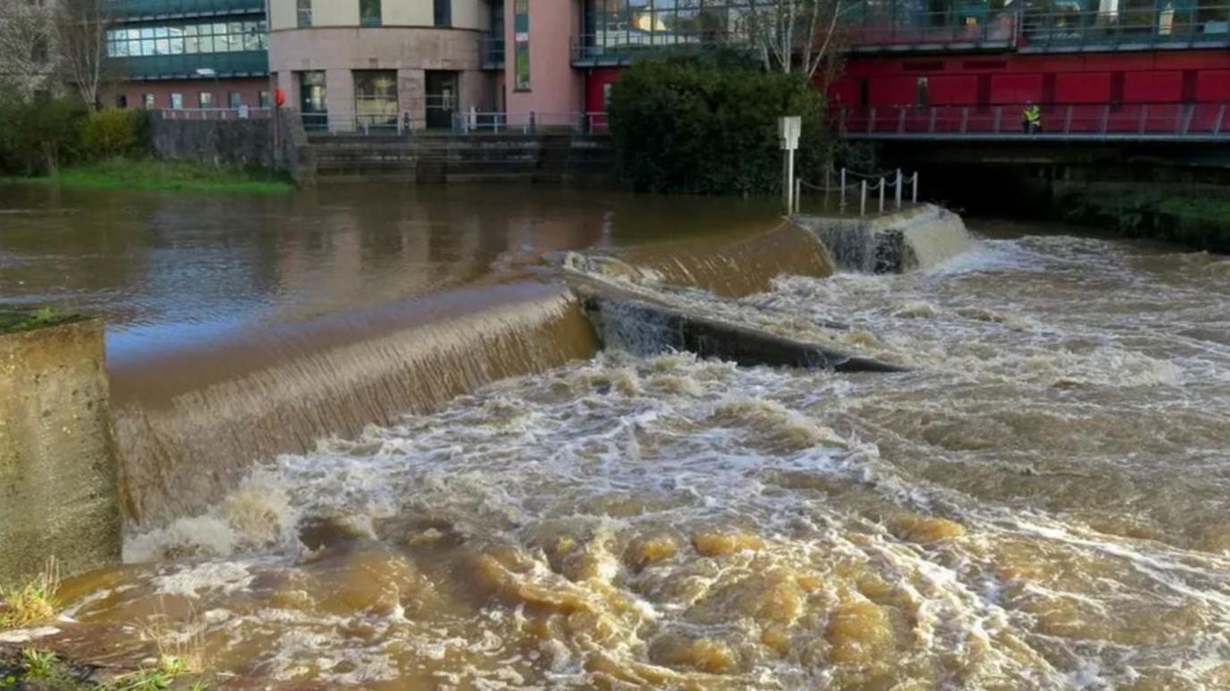 The weir in Haverfordwest, where the paddleboarders got into trouble. An image of fast-flowing water in a river beneath the weir.