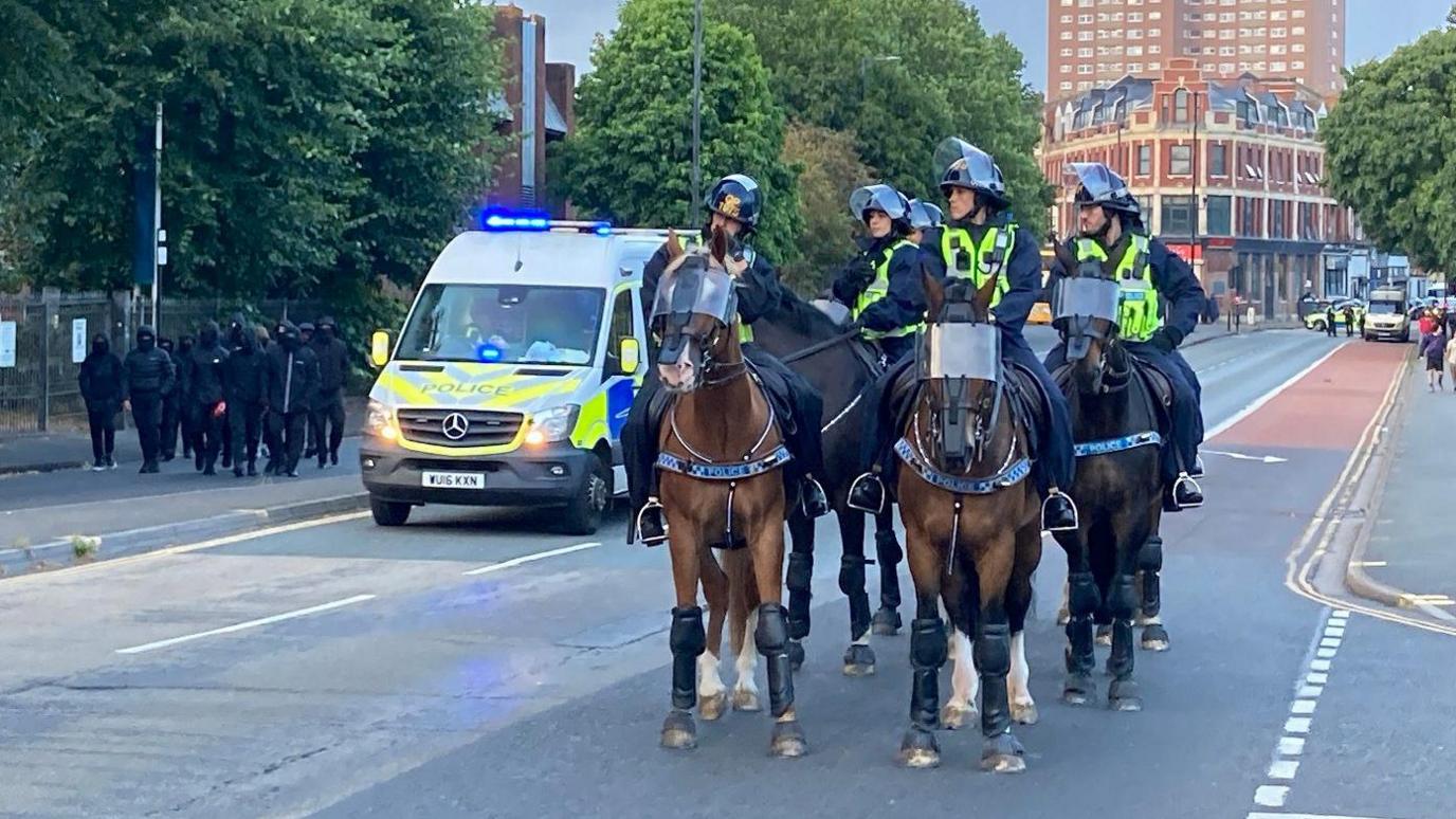 A group of police on horseback proceed down Old Market in Bristol