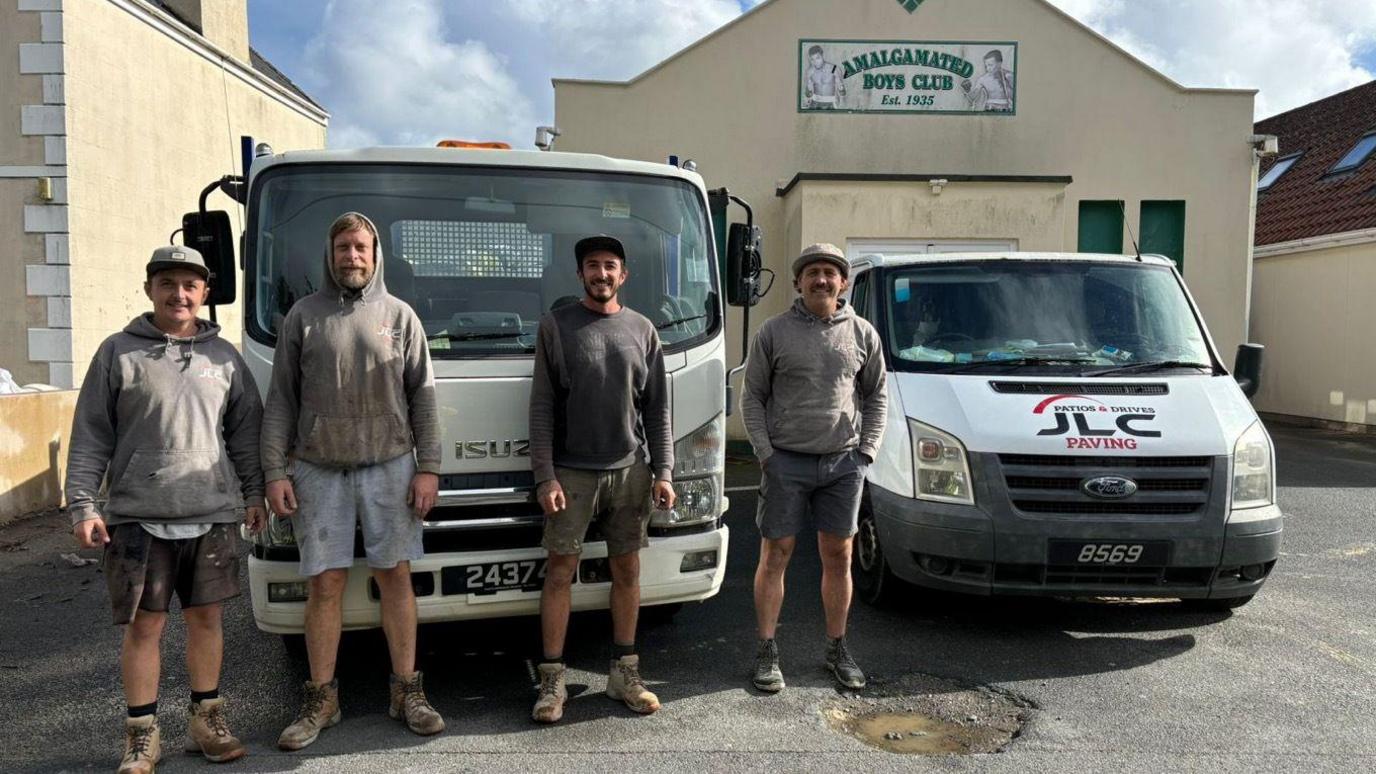 Four employees of JLC Paving standing in front of two vans outside the Amalgamated Boxing Club