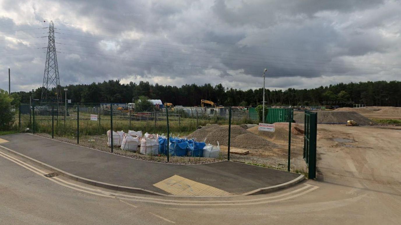 A Google Streetview of the site which has green metal fencing at the perimeter