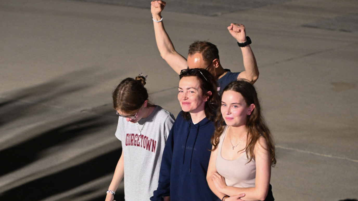 US-Russian journalist Alsu Kurmasheva (C) smiles as she walks with her husband Pavel Butorin and their daughters Miriam Butorin and Bibi Butorinas at Joint Base Andrews in Maryland