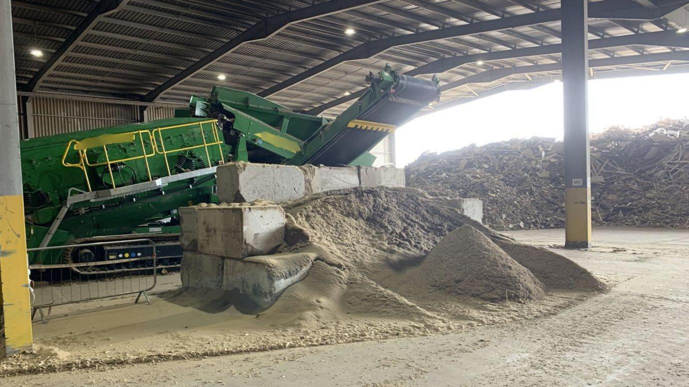 Piles of wood and wood dust inside the recycling centre