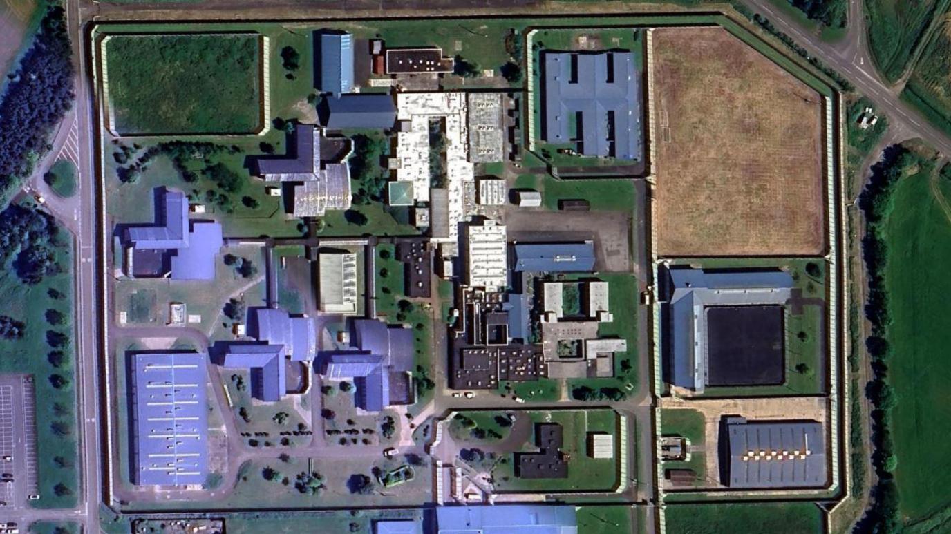 Aerial view of HMP Northumberland. There are a number of large buildings inside a fence.