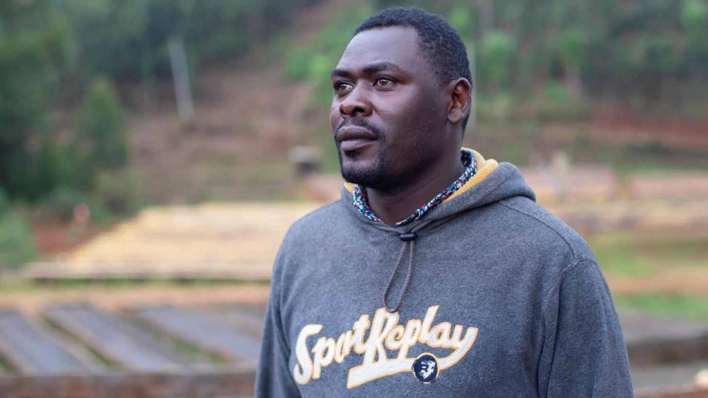 Simon Macharia, one of the Kenyan coffee farmers stands a coffee processing plant in Komothai, Kenya