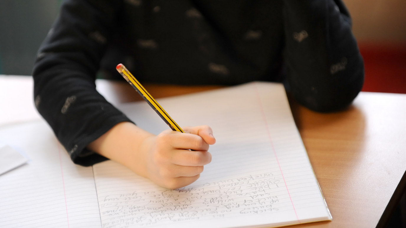 Child writing in textbook