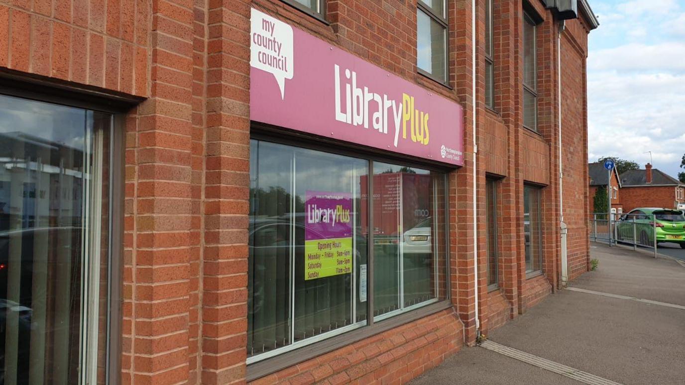 A closeup of the library entrance with a glass frontage.