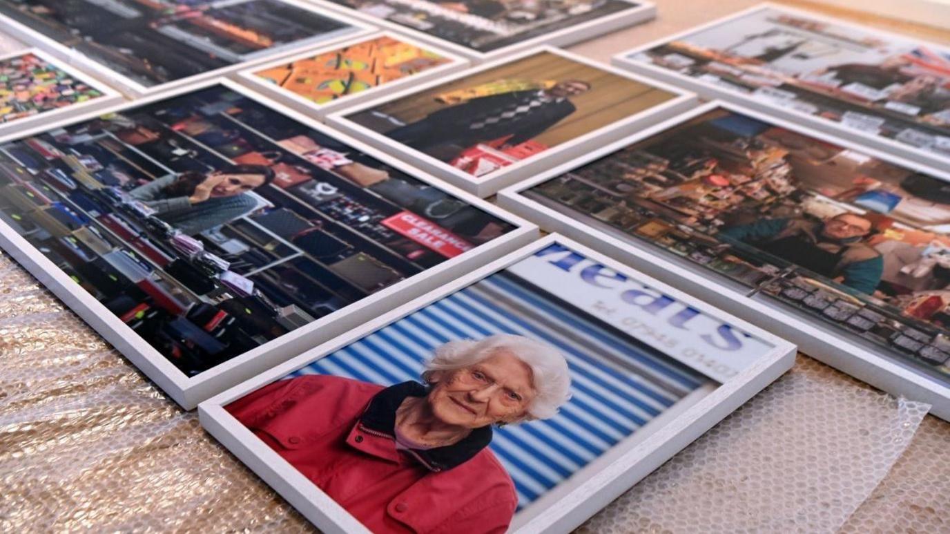 A selection of framed portrait photographs laid on bubble wrap on a table.
