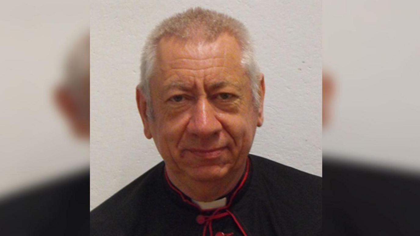 An elderly male vicar.