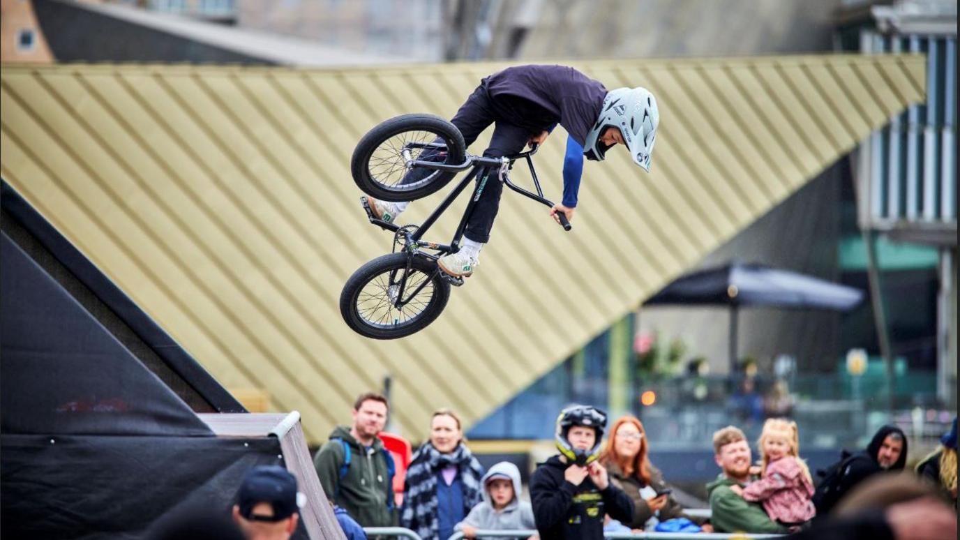 Bicycle rider flies over a ramp at the 2024 We Inve