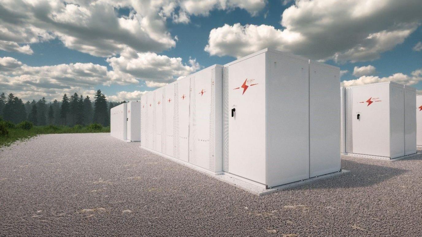 An artist's impression of the battery energy storage system, known as BESS. It shows a row of large white storage units on concrete ground near to woodland.