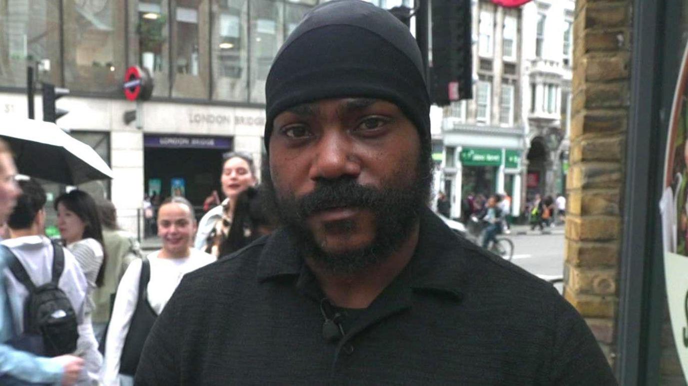 Shaun Thompson stands across the road from an entrance to London Bridge tube station